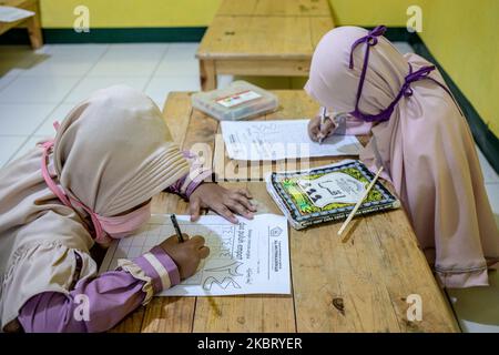 Les enfants apprennent à écrire des lettres arabes à Depok, Indonésie, on 1 juillet 2020. L'école Quran de Cinere, Depok, West Java a tenu l'école face à face dans l'enseignement de quran après une longue période de verrouillage partiel dans la région. L'école a appliqué la procédure de santé pour prévenir la propagation du virus corona. (Photo par Donal Husni/NurPhoto) Banque D'Images