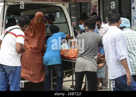 Une patiente attend avec ses proches devant l'hôpital du Collège médical de Dhaka pour être admise pour recevoir un traitement pendant la pandémie du coronavirus à Dhaka, au Bangladesh, sur 03 juillet 2020. (Photo par Mamunur Rashid/NurPhoto) Banque D'Images