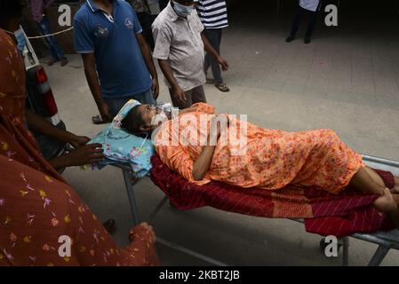 Une patiente attend avec ses proches devant l'hôpital du Collège médical de Dhaka pour être admise pour recevoir un traitement pendant la pandémie du coronavirus à Dhaka, au Bangladesh, sur 03 juillet 2020. (Photo par Mamunur Rashid/NurPhoto) Banque D'Images