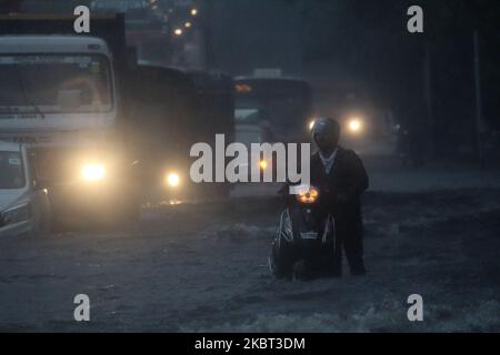 Un homme pousse un scooter alors qu'il se déplace sur une route inondée lors de fortes pluies à Mumbai, Inde sur 04 juillet 2020. La mousson en Inde dure officiellement de juin à septembre. (Photo par Himanshu Bhatt/NurPhoto) Banque D'Images