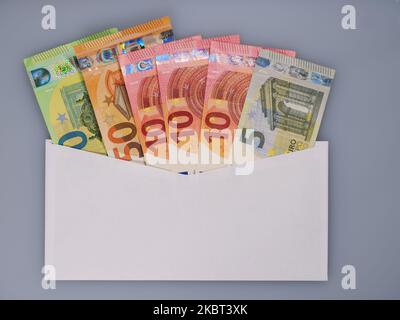 Euro argent dans enveloppe sur fond blanc. Salaires dans une enveloppe, corruption et corruption concept. Banque D'Images