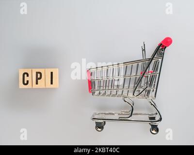 Chariot de supermarché avec blocs de bois avec mot CPI sur fond blanc. IPC, symbole de l'indice des prix à la consommation Banque D'Images