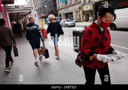 Une femme portant un masque et des gants regarde un journal sur Oxford Street à Londres, en Angleterre, sur 6 juillet 2020. L'Angleterre a fait des pas importants vers la reprise de la vie normale au cours du week-end avec l'assouplissement des restrictions de verrouillage du coronavirus dans le secteur de l'accueil, permettant ainsi aux bars et aux restaurants de rouvrir, ainsi qu'un passage à une règle de distance sociale d'un mètre plus. Pendant ce temps, Covid-19 décès dans tout le Royaume-Uni s'élèvent à 44 236, dont 16 autres enregistrés aujourd'hui. (Photo de David Cliff/NurPhoto) Banque D'Images