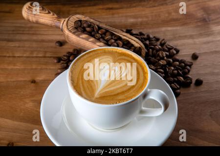 Grains de café rôtis avec cappuccino et motif mousse à pulsations Banque D'Images