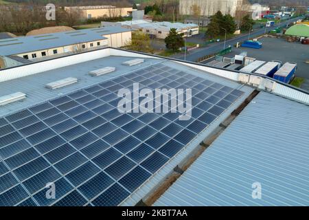 Vue aérienne des panneaux solaires photovoltaïques bleus montés sur le toit d'un bâtiment industriel pour produire de l'électricité écologique verte. Production de Banque D'Images