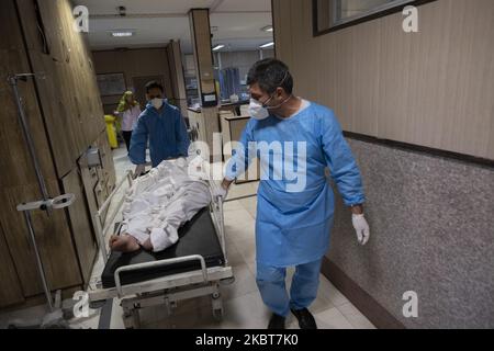 Deux membres du personnel médical iranien portant une combinaison protectrice portant un nouveau coronavirus par un lit mobile dans une section COVID-19 de l'hôpital de Firoozabadi, dans le quartier de Shahre-Rey, dans le sud de Téhéran, à 20 juin 2020. (Photo de Morteza Nikoubazl/NurPhoto) Banque D'Images