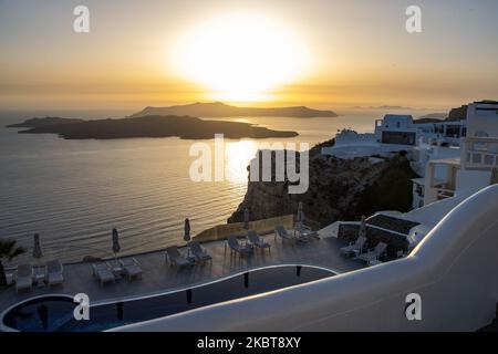 Coucher de soleil sur une piscine et huses blanchies à la chaux. Vue sur le coucher du soleil depuis Thera sur l'île de Santorin, Cyclades dans la mer Egée en Grèce. Quelques touristes et les habitants apprécient le coucher de soleil magique sur le volcan à Fira alors que le pays a ouvert les aéroports et a permis aux touristes de venir après 1 juillet en raison de la pandémie du coronavirus Covid-19 mesures générales de confinement qui ont commencé à se relâcher depuis 15 juin. La Grèce a récemment rouvert la saison touristique d'été avec le Premier ministre Kyriakos Mitsotakis ayant un discours de Santorin pendant le coucher du soleil pour relancer la saison touristique sur laquelle l'économie grecque est fortement basée Banque D'Images