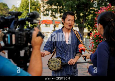 Takashi est un homme de 40 ans d'Okinawa, au Japon. Il y a un an, il était chef de sushi dans sa ville natale. Maintenant, il joue sanshi - instrument traditionnel d'Okinawa dans les rues de Varna, Bulgarie, à plus de 15 000 km de la maison. L'année dernière, après avoir divorcé avec sa femme, Takashi a décidé de prendre le temps de faire ce qu'il voulait toujours faire - voyager dans le monde, rencontrer de nouvelles personnes et partager avec eux des valeurs japonaises traditionnelles - comme chérir notre nature, nos langues et les autres. Il voyage principalement en vélo. Il utilise parfois des trains ou des ferries, mais jamais des avions - ils ne sont pas écologiques mais Banque D'Images