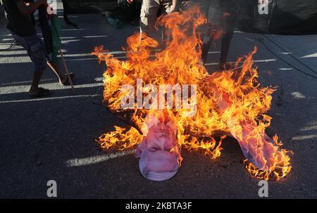 Les manifestants palestiniens brûlent des pancartes représentant le président américain Donald Trump et le Premier ministre israélien Benjamin Netanyahou lors d'une protestation contre le projet d'Israël d'annexer des parties de la Cisjordanie occupée par Israël, près du passage d'Erez israélien dans le nord de la bande de Gaza 9 juillet 2020. (Photo de Majdi Fathi/NurPhoto) Banque D'Images