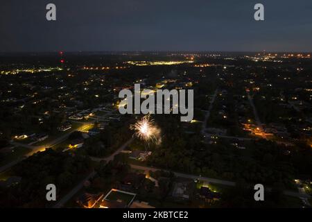 Vue aérienne des feux d'artifice lumineux qui explosent avec des lumières colorées sur les maisons de banlieue dans le quartier résidentiel lors des vacances de l'indépendance des États-Unis Banque D'Images