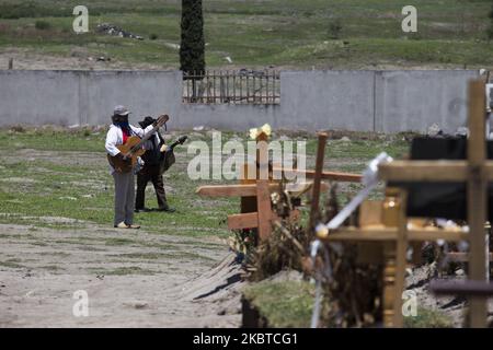 Personne debout devant une clôture au cimetière de Valle de Chalco, au Mexique, sur 10 juillet 2020. Depuis la crise sanitaire générée par la COVID-19, dans le cimetière municipal de Valle de Chalco, les scènes quotidiennes n'ont été perturbées que par l'utilisation de masques buccaux sur les parents et les musiciens qui déconsidèrent le défunt avec des chansons. Certains cercueils sont enveloppés dans du plastique par des protocoles de maisons funéraires. (Photo par Cristian Leyva/NurPhoto) Banque D'Images