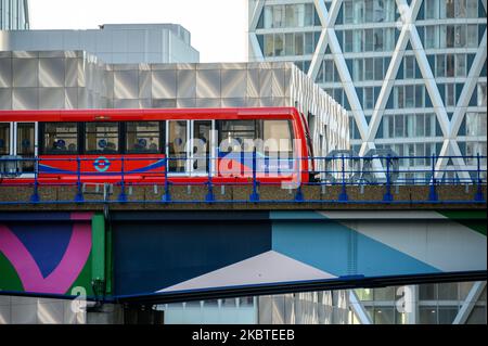 LONDRES - 4 novembre 2020: Docklands Light Railway le train DLR traverse le pont à Canary Wharf avec des immeubles de bureaux modernes en arrière-plan Banque D'Images