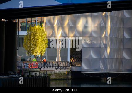 LONDRES - 4 novembre 2020 : les ouvriers du bâtiment baignaient dans la lumière dorée du soleil à Canary Wharf Banque D'Images