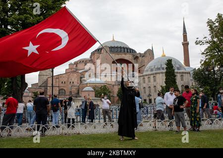 Les personnes qui visitent Sainte-Sophie posent avec des drapeaux turcs sur 15 juillet 2020 à Istanbul, en Turquie. Le Conseil d'État, le plus haut organe administratif de la Turquie, a révoqué le statut de musée de Sainte-Sophie au sixième siècle, ouvrant la voie à son retour en mosquée. Le président a annoncé sa décision vendredi après la décision du tribunal et le monument a été fermé depuis, mais de nombreuses personnes ont visité le site et pris des photos avec les drapeaux turcs à l'occasion de l'anniversaire de la tentative de coup d'État militaire de 15 juillet en 2016. (Photo par Erhan Demirtas/NurPhoto) Banque D'Images