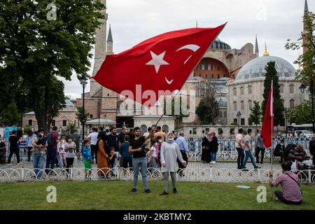 Les personnes qui visitent Sainte-Sophie posent avec des drapeaux turcs sur 15 juillet 2020 à Istanbul, en Turquie. Le Conseil d'État, le plus haut organe administratif de la Turquie, a révoqué le statut de musée de Sainte-Sophie au sixième siècle, ouvrant la voie à son retour en mosquée. Le président a annoncé sa décision vendredi après la décision du tribunal et le monument a été fermé depuis, mais de nombreuses personnes ont visité le site et pris des photos avec les drapeaux turcs à l'occasion de l'anniversaire de la tentative de coup d'État militaire de 15 juillet en 2016. (Photo par Erhan Demirtas/NurPhoto) Banque D'Images