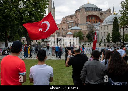 Les personnes qui visitent Sainte-Sophie posent avec des drapeaux turcs sur 15 juillet 2020 à Istanbul, en Turquie. Le Conseil d'État, le plus haut organe administratif de la Turquie, a révoqué le statut de musée de Sainte-Sophie au sixième siècle, ouvrant la voie à son retour en mosquée. Le président a annoncé sa décision vendredi après la décision du tribunal et le monument a été fermé depuis, mais de nombreuses personnes ont visité le site et pris des photos avec les drapeaux turcs à l'occasion de l'anniversaire de la tentative de coup d'État militaire de 15 juillet en 2016. (Photo par Erhan Demirtas/NurPhoto) Banque D'Images