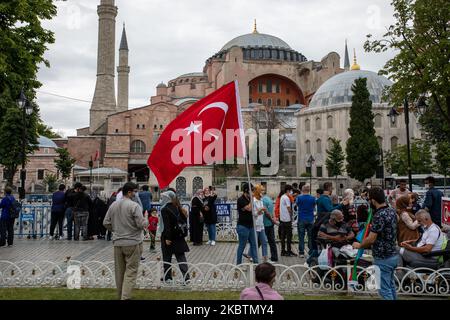 Les personnes qui visitent Sainte-Sophie posent avec des drapeaux turcs sur 15 juillet 2020 à Istanbul, en Turquie. Le Conseil d'État, le plus haut organe administratif de la Turquie, a révoqué le statut de musée de Sainte-Sophie au sixième siècle, ouvrant la voie à son retour en mosquée. Le président a annoncé sa décision vendredi après la décision du tribunal et le monument a été fermé depuis, mais de nombreuses personnes ont visité le site et pris des photos avec les drapeaux turcs à l'occasion de l'anniversaire de la tentative de coup d'État militaire de 15 juillet en 2016. (Photo par Erhan Demirtas/NurPhoto) Banque D'Images