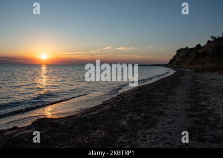 Coucher de soleil sur la plage de Paralia Epanomi en Grèce sur 16 juillet 2020. Epanomi est situé près de la destination touristique populaire de Chalkidiki et de la ville de Thessalonique, touchant le sable doré de la Méditerranée avec l'eau transparente du golfe Thermaikos et de la mer Égée. Le soleil se couche derrière la mer et les montagnes créant des couleurs chaudes de l'heure magique dans le ciel. (Photo de Nicolas Economou/NurPhoto) Banque D'Images