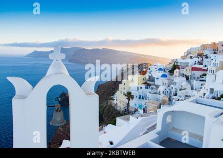 Vue panoramique sur le magnifique paysage pittoresque de la ville d'Oia, Grèce, sur 6 juillet 2020 pendant l'heure magique, le coucher du soleil et les églises à dôme bleu. Maisons ou hôtels avec la célèbre architecture traditionnelle des îles Cyclades au-dessus de la caldeira du volcan et de la mer Égée. L'île de Santorini est l'une des destinations grecques et méditerranéennes les plus célèbres, célèbre pour le volcan actif et le coucher du soleil, elle est considérée comme une destination romantique et relaxante pour les vacances d'été et de lune de miel. Pendant le coucher du soleil, il y a habituellement des milliers de couples, des touristes du monde entier Banque D'Images