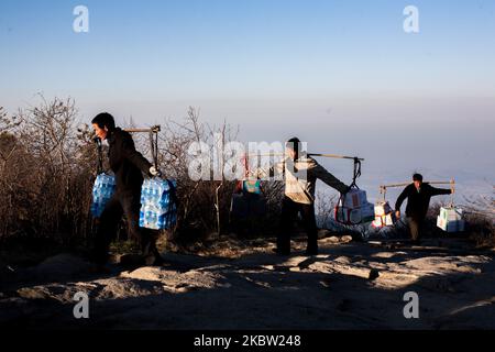 Taishan, Chine, le 23 avril 2011. Les hommes apportent de la nourriture et de l'eau au sommet du Mont Tai, une montagne d'importance historique et culturelle située au nord de la ville de Tai'an, dans la province de Shandong. (Photo par Emeric Fohlen/NurPhoto) Banque D'Images