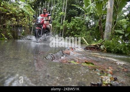 Un homme de village fait de la moto dans la rue inondée de Manikganj, près de Dhaka, au Bangladesh, sur 24 juillet 2020. Le nombre de morts des fortes pluies de mousson en Asie du Sud a atteint près de 200. Près de quatre millions de personnes ont été touchées par les inondations de la mousson en Asie du Sud. (Photo par Mamunur Rashid/NurPhoto) Banque D'Images