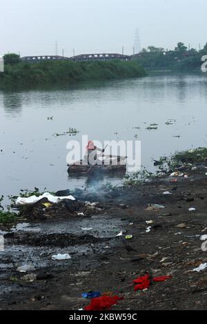 Un collecteur de déchets est vu ramasser du plastique sur un bateau de fortune le long de la rivière Yamuna à New Delhi sur 24 juillet 2020. (Photo de Mayank Makhija/NurPhoto) Banque D'Images