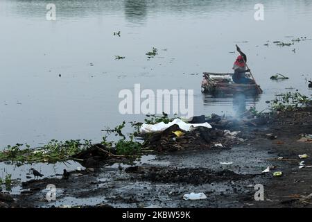 Un collecteur de déchets est vu ramasser du plastique sur un bateau de fortune le long de la rivière Yamuna à New Delhi sur 24 juillet 2020. (Photo de Mayank Makhija/NurPhoto) Banque D'Images