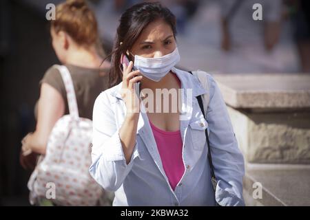 Une femme portant un masque est vue en utilisant son téléphone portable à Varsovie, Pologne sur 27 juillet 2020. Les cas quotidiens en Pologne ont augmenté de plus d'un millier en seulement deux jours pendant le week-end. Au cours des derniers mois, de nouveaux cas ont plané autour de 300 par jour. Par temps chaud, les gens se rendent dans les points d'intérêt publics de la côte et dans les montagnes sans masques ni distances sociales. (Photo de Jaap Arriens/NurPhoto) Banque D'Images