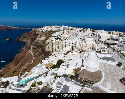 Photo panoramique d'un drone aérien de célèbre village méditerranéen traditionnel d'Oia dans l'île volcanique de Santorini dans les Cyclades dans la mer Egée en Grèce. L'île est célèbre pour le coucher de soleil magique, l'architecture des maisons blanchies à la chaux, les hôtels avec vue sur la piscine et les églises à dôme bleu sur le bord raide de la falaise. Santorini est une destination populaire pour la lune de miel, les propositions, les mariages et les couples de partout dans le monde, mais est généralement surpeuplé de touristes asiatiques car il est considéré sur les meilleurs endroits romantiques dans le monde. Les autorités grecques ont levé le Covi Banque D'Images