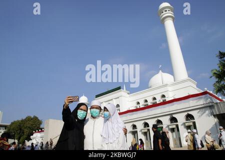 Une famille de musulmans indonésiens portant un masque facial protecteur a pris une photo après avoir assisté à une prière d'Eid Al Adha à la mosquée Al Azhar à Djakarta, Indonésie sur 31 juillet 2020. Le gouvernement indonésien permet aux musulmans de tenir la prière d'Eid Al Adha avec des protocoles de santé stricts, sauf dans les zones qui sont encore désignées comme zones rouges Covid-19. (Photo par Aditya Irawan/NurPhoto) Banque D'Images