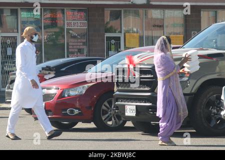 Femme sikh portant un masque facial pour la protéger du nouveau coronavirus (COVID-19) lorsqu'elle livre des boîtes de bonbons indiens à la voiture d'un couple sikh nouvellement marié à Brampton, Ontario, Canada sur 01 août 2020. (Photo de Creative Touch Imaging Ltd./NurPhoto) Banque D'Images