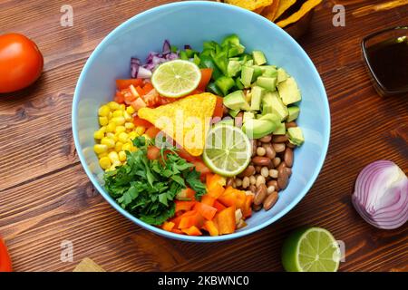 Caviar de cowboy biologique maison avec haricots de maïs, tomates, poivrons, lime, avocat, Fond en bois d'oignon Banque D'Images