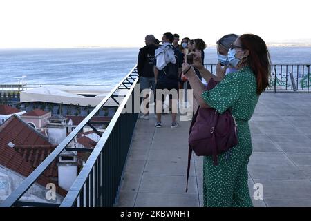 Plusieurs touristes portant des masques protecteurs marchent près du point de vue de Porta do sol, Lisbonne, Portugal, le 4 août 2020. Le Portugal s'est enregistré lundi, à 3 août, son premier jour sans décès de la COVID-19 depuis la mi-mars et, en même temps, a signalé le plus faible nombre de nouveaux cas en près de trois mois. L'absence de décès a été soulignée lors d'une conférence de presse comme une « note positive d'espoir » par le secrétaire d'État à la Santé, António Lacerda Sales. (Photo par Jorge Mantilla/NurPhoto) Banque D'Images