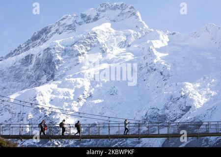 Les randonneurs traversent un pont tournant sur la piste de Hooker Valley à Aoraki / Parc national du Mont Cook dans l'île du Sud, en Nouvelle-Zélande, sur 05 août 2020. Le point d'observation à la fin de la piste de Hooker Valley se termine par un lac Hooker moucheté d'iceberg et la vue la plus proche d'Aoraki/Mount Cook. Le mont Cook se trouve au milieu de la chaîne de montagnes des Alpes du Sud et, à partir de 2020, sa hauteur est enregistrée à 3724m du niveau de la mer. (Photo de Sanka Vidanagama/NurPhoto) Banque D'Images