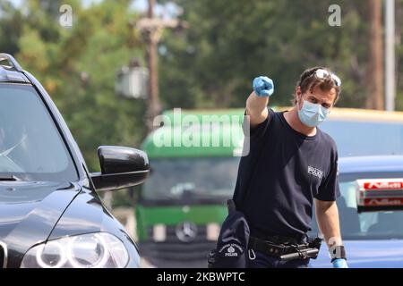 Un agent de police montre une voiture pour l'essai. La Grèce vérifie les touristes arrivant aux frontières gréco-bulgares de 31 juillet 2020 pour Covid-19. Les voyageurs en voiture et en bus de toute l'Europe mais surtout de Bulgarie, Roumanie, République tchèque et Pologne arrivent aux frontières grecques bulgares de Promahona - Kulata, point d'entrée en Grèce pour les vacances et ils sont contrôlés pour les coronavirus. La Grèce a levé l'interdiction de voyager depuis 1 juillet et a relancé la saison touristique. Les touristes arrivant doivent porter le formulaire spécial de localisation de passager pour chaque individu, un nouveau document obligatoire pour en Banque D'Images