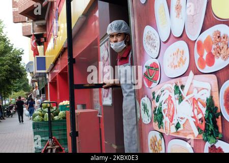 Un chef portant un masque protecteur en attendant ses clients devant son restaurant dans le centre de la ville d'Eskisehir, Turquie sur 10 août 2020. (Photo de Sayed Najafizada/NurPhoto) Banque D'Images