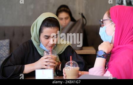 Deux femmes iraniennes portant un masque facial protecteur se trouvent dans un café du nord de Téhéran, à la suite de la nouvelle épidémie de coronavirus (COVID-19) en Iran, à 9 août 2020. (Photo de Morteza Nikoubazl/NurPhoto) Banque D'Images