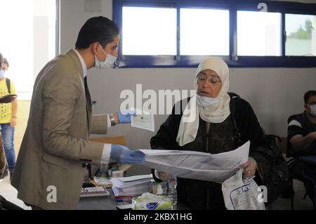 Les agents électoraux attendent qu'une femme vote le premier jour des élections sénatoriales à l'intérieur d'un bureau de vote au Caire, Égypte, le mardi 11 août 2020. (Photo de Mohamed Mostafa/NurPhoto) Banque D'Images