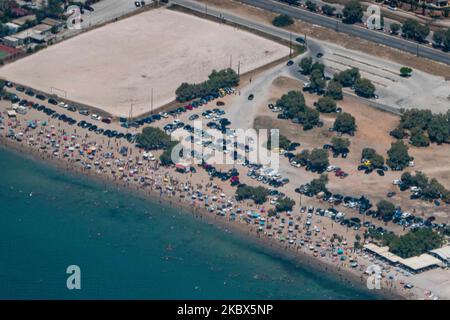 La plage publique de Varkiza, en banlieue de la capitale grecque Athènes, est surpeuplée d'un avion avec des milliers de personnes, des parasols et des chaises longues sur le sable, mais elle est également visible au célèbre Varkiza Resort et au bar de plage populaire Yabanaki. Le gouvernement local ajoute de nouvelles mesures de sécurité telles que les problèmes sociaux, la modification des heures de travail, l'utilisation obligatoire du masque facial, etc contre la propagation du coronavirus Covid-19 épidémie pandémique après avoir détendu le confinement, les voyages et l'interdiction de circulation, quarantaine il y a quelques semaines, en essayant de relancer la saison touristique, mais récemment, le nombre de cas a commencé incre Banque D'Images