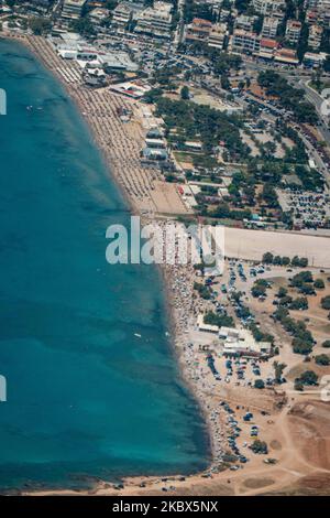 La plage publique de Varkiza, en banlieue de la capitale grecque Athènes, est surpeuplée d'un avion avec des milliers de personnes, des parasols et des chaises longues sur le sable, mais elle est également visible au célèbre Varkiza Resort et au bar de plage populaire Yabanaki. Le gouvernement local ajoute de nouvelles mesures de sécurité telles que les problèmes sociaux, la modification des heures de travail, l'utilisation obligatoire du masque facial, etc contre la propagation du coronavirus Covid-19 épidémie pandémique après avoir détendu le confinement, les voyages et l'interdiction de circulation, quarantaine il y a quelques semaines, en essayant de relancer la saison touristique, mais récemment, le nombre de cas a commencé incre Banque D'Images