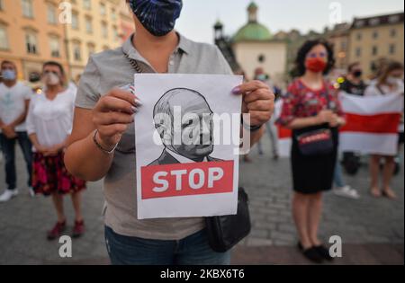 Un manifestant tient une image d'Alexandre Loukachenko. Samedi soir, des membres de la diaspora biélorusse locale, des militants et des supporters locaux se tapis pour exprimer leur solidarité avec les Biélorusses lors du rassemblement de solidarité organisé sur la place du marché principal de Cracovie. Sur 15 août 2020, à Cracovie, en Pologne. (Photo par Artur Widak/NurPhoto) Banque D'Images