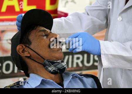 Un agent de santé recueille un échantillon d'écouvillon nasal auprès d'un patient pour le test rapide d'antigène Covid-19, sur le chemin Mata Sundri, à 17 août 2020, à New Delhi, en Inde. La camionnette mobile Covid-19 passe par des zones de haute densité, effectuant des tests rapides d'antigène pour détecter et enrayer la propagation du virus corona. Ce service est fourni gratuitement par le gouvernement dans chaque district de la capitale nationale. (Photo de Mayank Makhija/NurPhoto) Banque D'Images