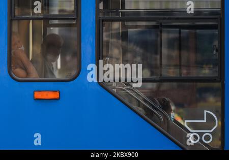 Personnes portant un masque médical à l'intérieur d'un tramway local vu sur le pont Jozef Pilsudski récemment rénové dans le quartier de Podgorze à Cracovie. Sur 17 août 2020, à Cracovie, en Pologne. (Photo par Artur Widak/NurPhoto) Banque D'Images