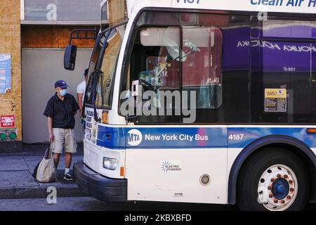 Les gens qui se préparent pour un autobus MTA sont vus dans la rue main, Flushing dans le Queens alors que la ville de New York poursuit la phase 4 de réouverture suite aux restrictions imposées pour ralentir la propagation du coronavirus à 20 août 2020 dans la ville de New York. La quatrième phase permet les arts et le divertissement de plein air, les événements sportifs sans fans et la production de médias. MTA Retour porte avant embarquement de bus et recouvrement de tarifs démarrage de 31 août 2020. (Photo de John Nacion/NurPhoto) Banque D'Images