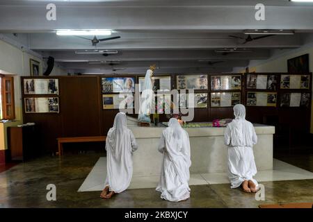 Les Nuns catholiques de l'ordre des Missionnaires de la Charité offre des prières au tombeau de Saint Teresa.Une dame prie devant une photo de Saint Teresa , à l'extérieur des Missionnaires de la Charité à Kolkata.Une dame offre ses prières de l'extérieur au tombeau de Saint Teresa . Cette année a marqué l'anniversaire de 110th ans de Sainte Thérèse de Kolkata. La célébration a été limitée cette année en raison de la hausse des cas de COVID-19 dans la ville. Les dévotés ont été autorisés à offrir la prière de l'extérieur des locaux de la maison des Missionnaires de la Charité de mère Teresa où repose la tombe de mère Teresa. (Photo par Debarchan Chatterjee/NurPho Banque D'Images