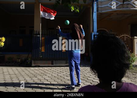 LIA (11), une étudiante de 6 e année à l'école primaire, tente de jeter la balle en plastique à la corbeille utilisée comme panier de basket-ball de fortune, comme elle fait sa tâche d'entraînement sportif de son professeur devant sa maison dans le village de Wanasari, Bekasi regency, province de Java Ouest, sur 28 août 2020. Le gouvernement indonésien ferme encore les écoles et met en place un système d'apprentissage en ligne pour prévenir la transmission du coronavirus Covid-19, le nombre de nouveaux cas continuant d'augmenter. (Photo par Aditya Irawan/NurPhoto) Banque D'Images