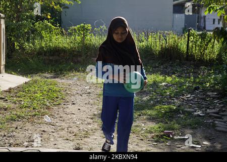 LIA (11), une étudiante de 6 e année à l'école primaire, faisant sa tâche de pratique sportive de son professeur devant sa maison dans le village de Wanasari, la régence de Bekasi, province de Java Ouest, sur 28 août 2020. Le gouvernement indonésien ferme encore les écoles et met en place un système d'apprentissage en ligne pour prévenir la transmission du coronavirus Covid-19, le nombre de nouveaux cas continuant d'augmenter. (Photo par Aditya Irawan/NurPhoto) Banque D'Images