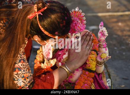 Un dévot murmure un souhait à l'oreille d'une idole de la déité hindoue Ganesha, dans le cadre d'un rituel à l'occasion de Ganesha Chaturthi, avant immersion dans le fleuve Brahmaputra, pendant les célébrations de Ganesh Chaturthi, à Guwahati, Assam, Inde vendredi, 28 août, 2020. (Photo de David Talukdar/NurPhoto) Banque D'Images