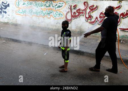 Un travailleur palestinien pulvérise des désinfectants dans une rue à la suite de l'épidémie de coronavirus (COVID-19), dans la ville de Gaza, à 28 août 2020. (Photo de Majdi Fathi/NurPhoto) Banque D'Images