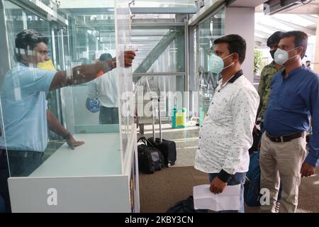 Un personnel de l'aéroport contrôle la température d'un passager à l'aéroport international Netaji Subhash Chandra Bose de Kolkata sur 03 septembre,2020.le gouvernement autorise 15 % de vols intérieurs en plus vers Delhi, Mumbai et Chennai. Avec le verrouillage dans le Bengale occidental étendu jusqu'à 20 septembre, l'aéroport de Kolkata a permis des vols entrants de six villes d'une manière limitée. Les vols au départ de six villes comme Delhi, Mumbai, Chennai, Ahmedabad, Pune et Nagpur seront autorisés de manière limitée à partir de septembre. (Photo de Debajyoti Chakraborty/NurPhoto) Banque D'Images